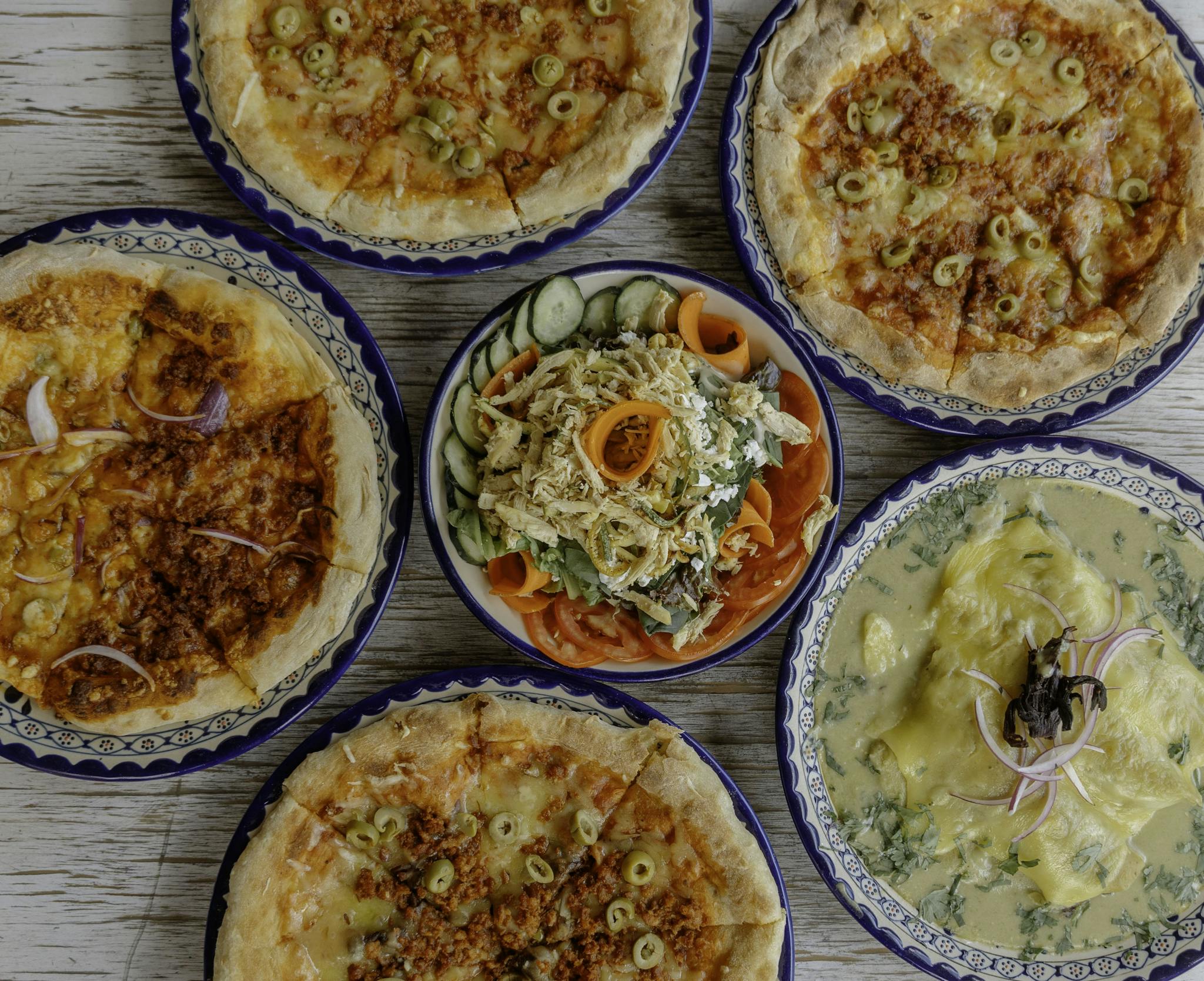 A Vibrant Spread Of Pizzas And Salads